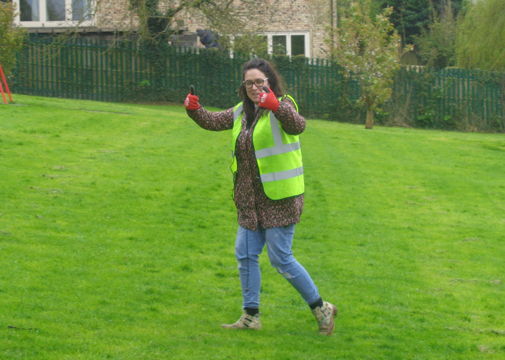 Community volunteer gives a thumbs up to the newly litter free grass